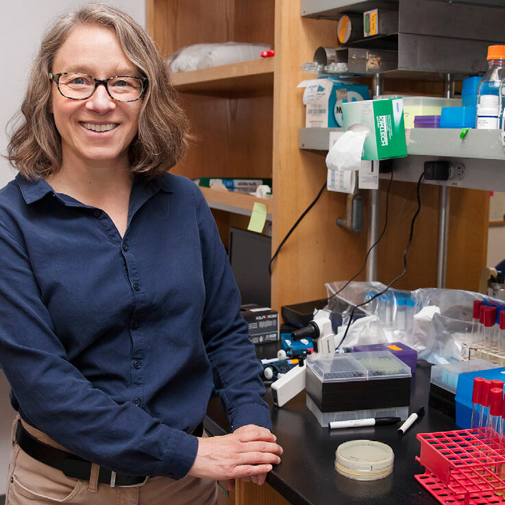 Professor Kathy Collins next to a bench in her lab